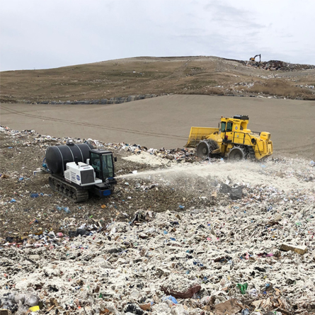 machines working in landfill covering waste